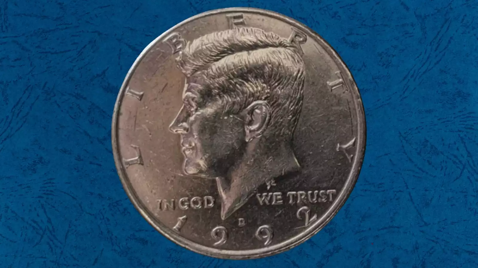 1992 Kennedy half dollar off-center strike error showing blank crescent area with date still visible