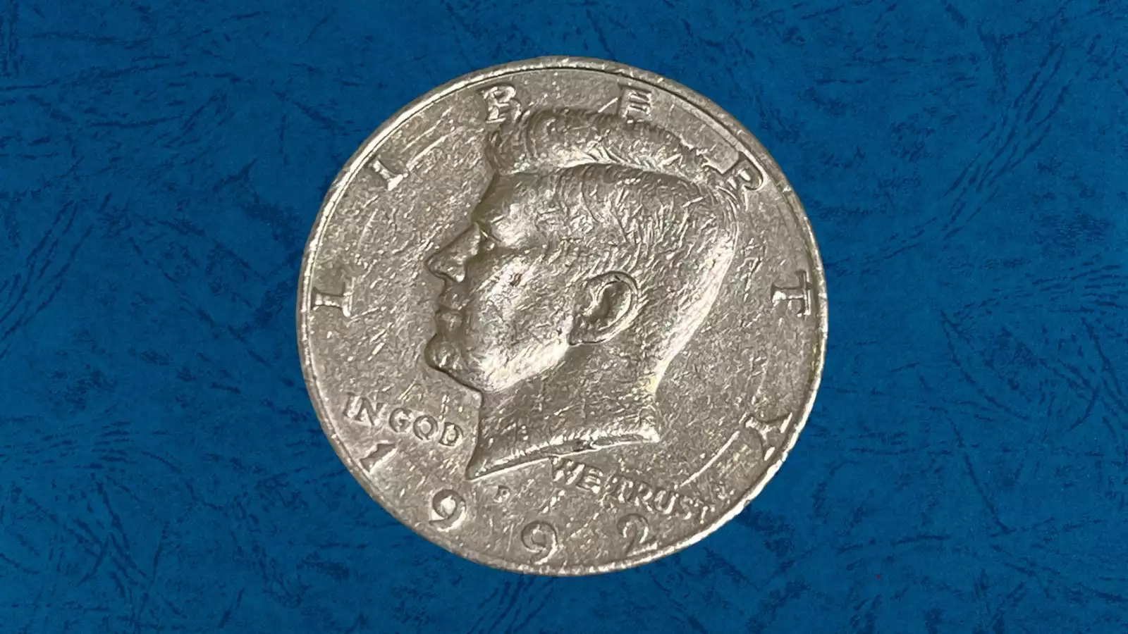 Close-up of 1992 Kennedy half dollar obverse showing die clash ghost images of reverse eagle design in the open fields